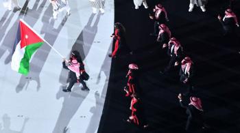لاعبان يحملان علم الأردن في افتتاح دورة الألعاب الآسيوية