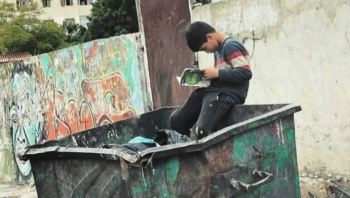 صورة ابهرت العقول ..  طفل في حاوية القمامة يقرأ كتاباً